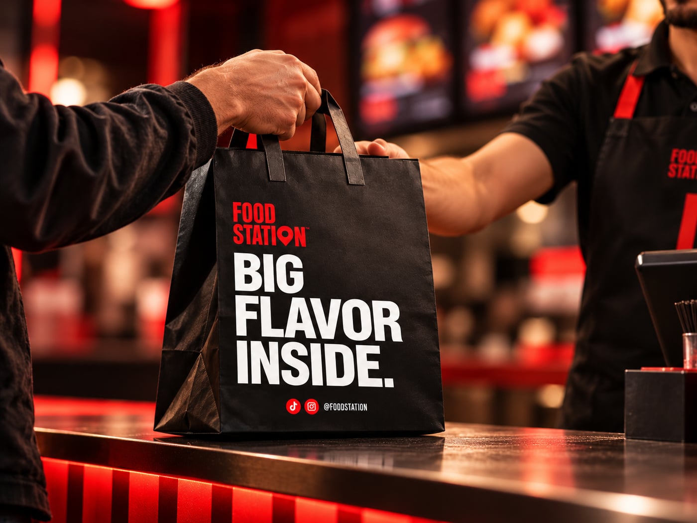 Au comptoir, un équipier tend un sac Food Station « Big flavor inside » à un client.